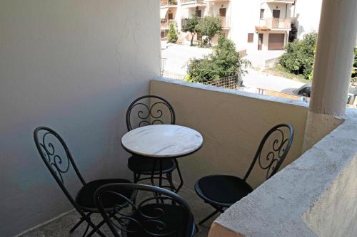 a small table and chairs sitting on a balcony at 1951 Suites in Kalabaka