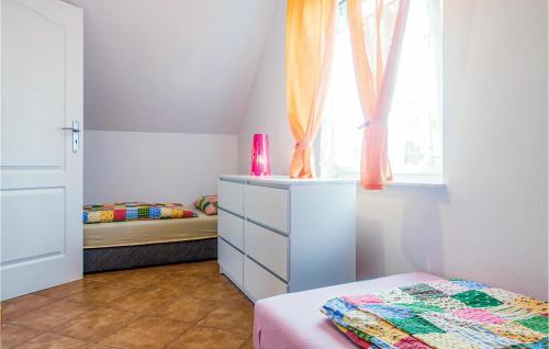 a bedroom with two beds and a dresser and a window at Dom Szeregowy in Darłowo