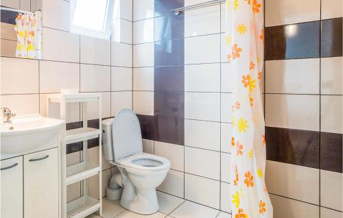 a bathroom with a toilet and a sink and a shower curtain at Dom Szeregowy in Darłowo