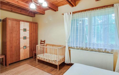 a bedroom with a crib and a large window at Amazing Home In Pobierowo With 2 Bedrooms And Wifi in Pobierowo