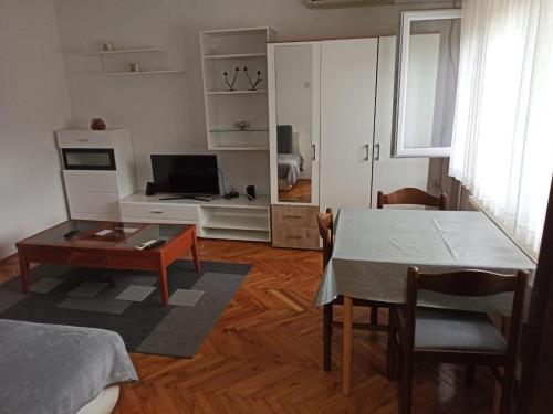 uma sala de estar com uma mesa e uma televisão em Apartman Matej em Slavonski Brod
