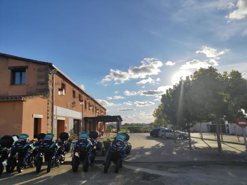 un grupo de motocicletas estacionadas en un estacionamiento en El Huésped del Sevillano AR, en Lagartera