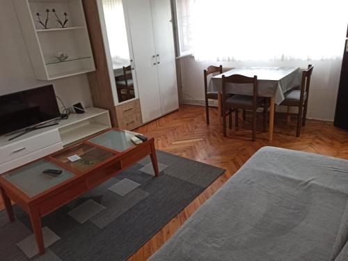 uma sala de estar com uma mesa e uma sala de jantar em Apartman Matej em Slavonski Brod
