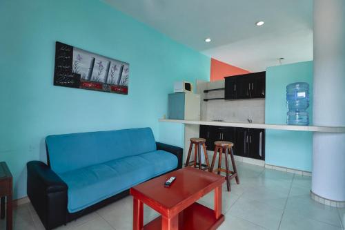 ein Wohnzimmer mit einem blauen Sofa und einem Tisch in der Unterkunft Los Angeles en el Paraiso in San Patricio - Melaque