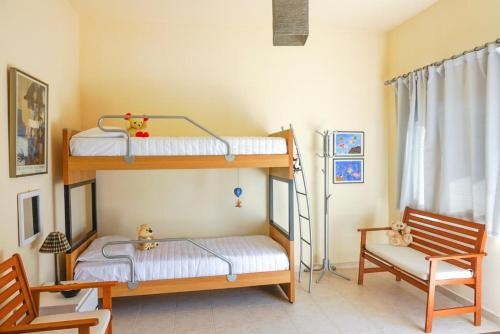 a bedroom with two bunk beds and a chair at Elafonisi Vacation Blue Apartment in Agios Padeleimon