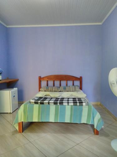 a bedroom with a bed with a wooden head board at Pousada Abacateiro in Vale do Capao