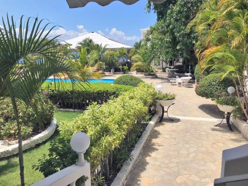 a resort yard with a swimming pool and palm trees at Piergiorgio Palace Hotel in Sosúa