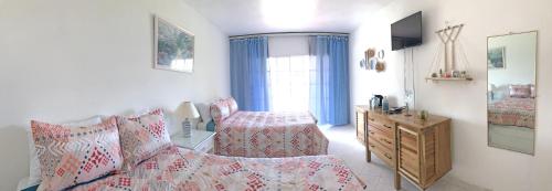 a bedroom with a bed and a dresser and a window at Piergiorgio Palace Hotel in Sosúa