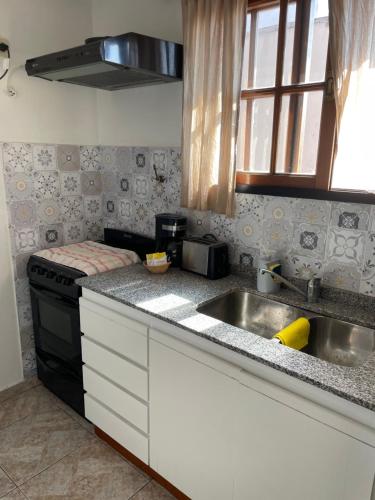 uma cozinha com um lavatório e um fogão em Alquilo departamento por dia. Zona castelar!!! em Castelar