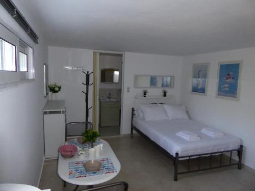 a small bedroom with a bed and a table at Elafonisi Vacation Green Studio in Agios Padeleimon