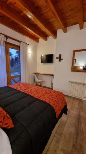 a bedroom with a large bed and a desk at Encanto del Rio in Villa La Angostura