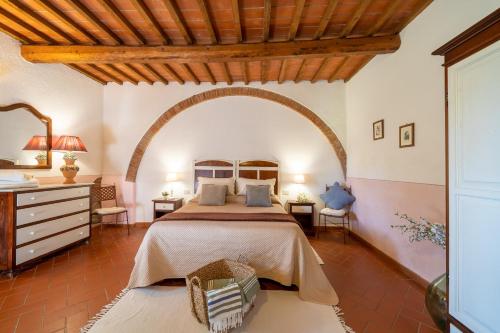 sypialnia z łóżkiem i drewnianym sufitem w obiekcie Agriturismo Canale w mieście Peccioli