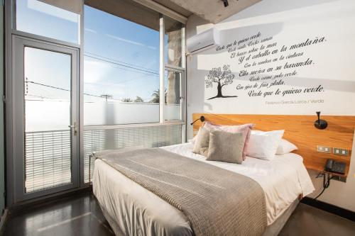 a bedroom with a bed and a large window at Verso Hotel in Valparaíso