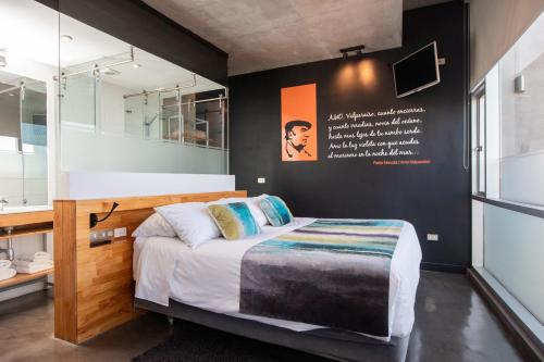 1 dormitorio con cama y espejo en Verso Hotel, en Valparaíso