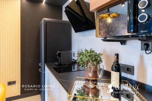 a kitchen with a counter with a bottle of wine at Urbanlux Olimpia Sleep & Park in Albacete