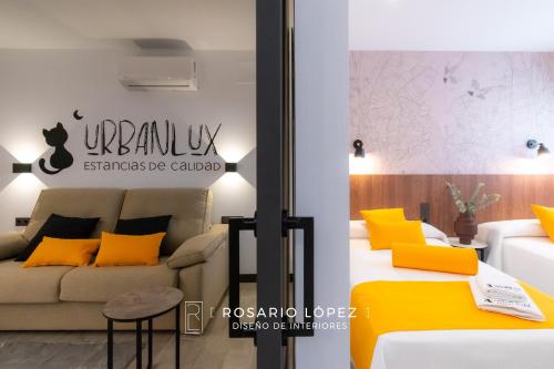 Habitación con sofá y cama con almohadas amarillas. en Urbanlux Olimpia Sleep & Park en Albacete