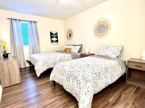 a bedroom with two beds and a mirror on the wall at *Prime Pad * King Bed * Long Term Stays* in Durham