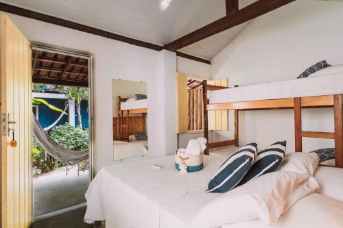 a bedroom with a bed with two pillows at Vila das Ondas Caraíva in Caraíva