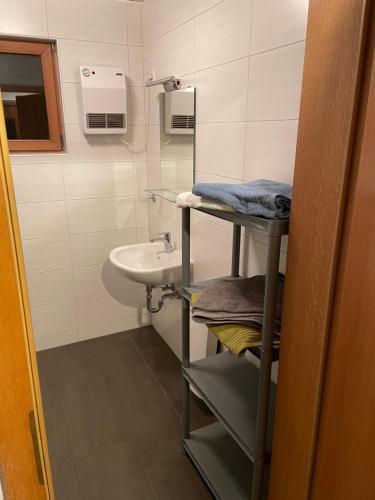 a bathroom with a sink and a toilet and a mirror at Bungalowdorf Lübben in Lübben