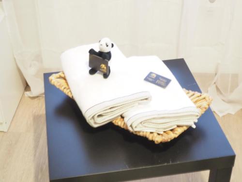 a panda sitting on a pile of towels on a table at Schöne Helle Wohnung in Mühlhausen