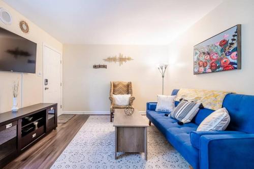 a living room with a blue couch and a tv at *Cool Crib * King Bed * Long Term Stays * Duke* in Durham