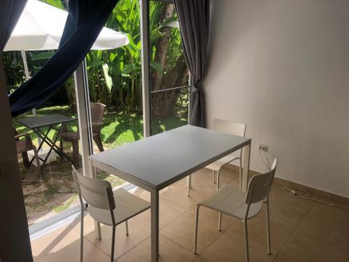 een tafel en stoelen in een kamer met een raam bij Studio Residencial Almendra in Cabarete
