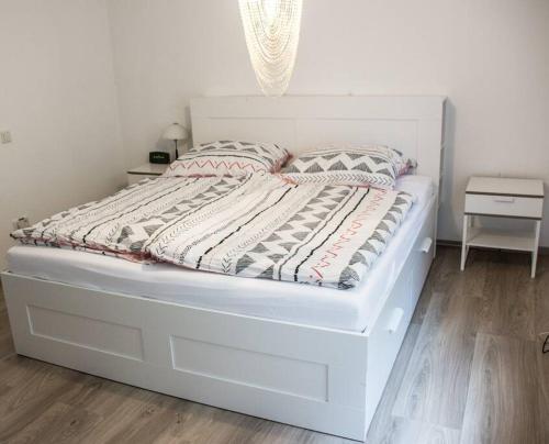 een wit bed in een slaapkamer met een witte muur bij Schöne Ferienwohnung in der Welterbe Region in Trechtingshausen