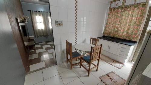- une cuisine avec une table, 2 chaises et un évier dans l'établissement Casa Bethel - De 3 a 5 minutos do Thermas, à Olímpia