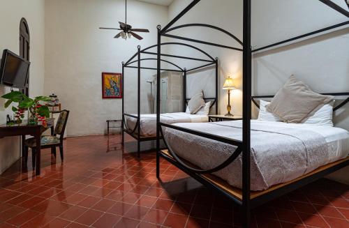 a bedroom with two beds and a ceiling fan at VILLA MERIDA BOUTIQUE HOTEL - Adults Only in Mérida