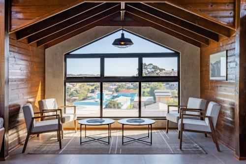 カンバラにあるPousada Serra Verdeのテーブルと椅子、大きな窓が備わる客室です。