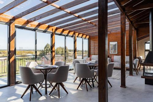 a room with tables and chairs and large windows at Pousada Serra Verde in Cambara do Sul