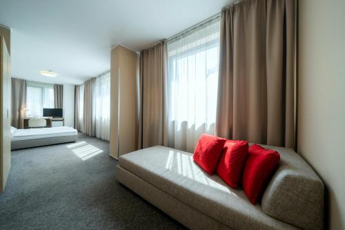 Pokój z łóżkiem z 2 czerwonymi poduszkami w obiekcie Hotel Ehrlich Prague w Pradze