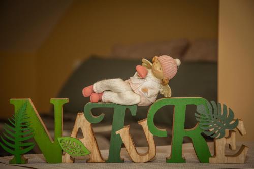 a toy monkey sitting on top of the word play at Oros House Apartmanház in Orosháza