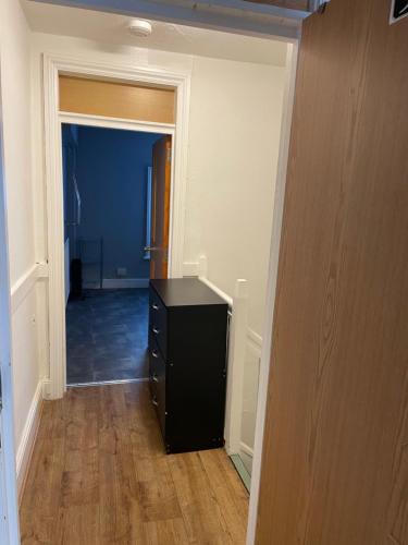 a hallway with a black dresser in a room at Bright Apartments in Peterborough