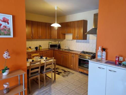 una cocina con armarios de madera y una mesa con sillas. en Tudor Apartman, en Szeged