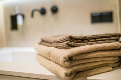 a pile of towels sitting on a counter in a bathroom at Apartament Migdałowy in Toruń