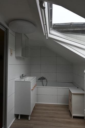 eine weiße Küche mit einem Waschbecken und einem Fenster in der Unterkunft Le Paradis Mosan in Waulsort