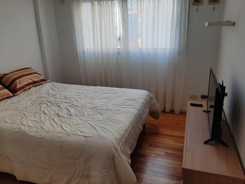 a bedroom with a bed and a flat screen tv at AMENABAR SUITES in Buenos Aires