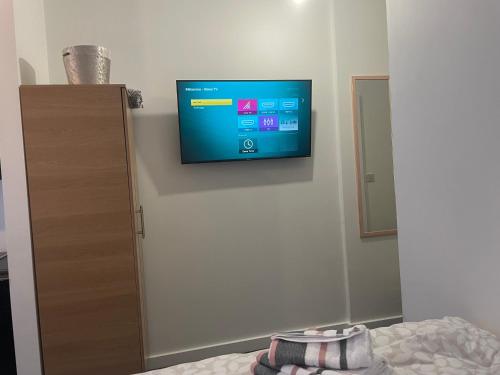 een flatscreen-tv aan de muur van een slaapkamer bij Bv Comfy Budget Studio At Quebec Street Bradford in Bradford