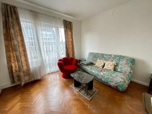 a living room with a couch and a red chair at Superbe appartement DUPLEX avec Jacuzzi in Brussels