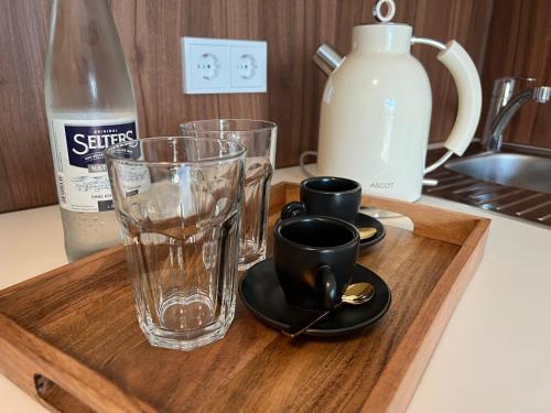 a wooden tray with cups and glasses on a kitchen counter at HHotel Augsburg in Augsburg