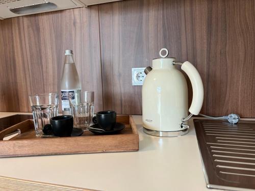 a tea kettle and cups on a kitchen counter at HHotel Augsburg in Augsburg