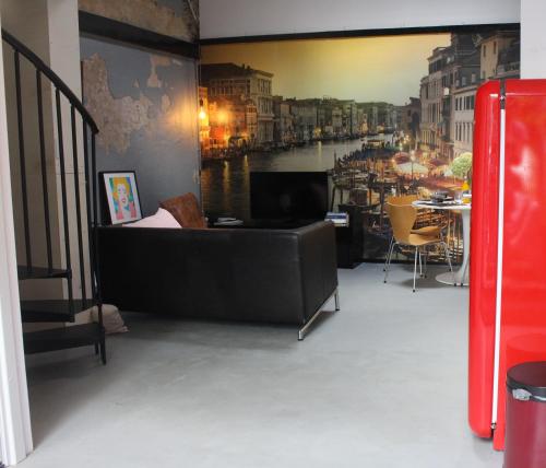 a couch in a room with a painting of a river at Achterhuis Slapen en Eten in Gouda