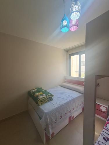 a small bedroom with a bed and a window at Azha Ain Sokhna apartment in Ain Sokhna
