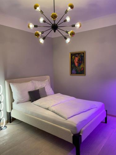 ein lila Schlafzimmer mit einem Bett mit einem Kronleuchter in der Unterkunft City Apartment Downtown Vienna in Wien