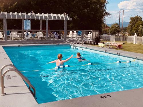 Duas raparigas estão a brincar numa piscina. em Carolina Motel em Franklin