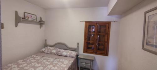 um pequeno quarto com uma cama e um armário de madeira em Apartamento MontEsquiBonito Bonito Apartamento en Yésero em Yésero