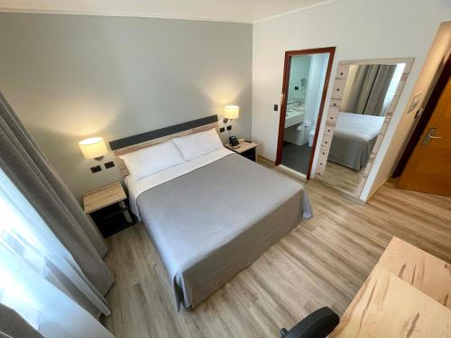 - une chambre d'hôtel avec un lit et un miroir dans l'établissement Diego de Almagro Providencia Express, à Santiago