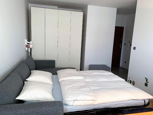 Una cama con sábanas blancas y almohadas. en A modern apartment for 2 people, en Cracovia