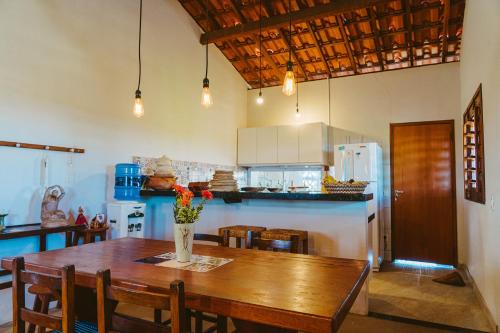 eine Küche mit Holztisch und ein Esszimmer in der Unterkunft Casa ampla c redes de descanso, Praia de Macapa PI in Luis Correia